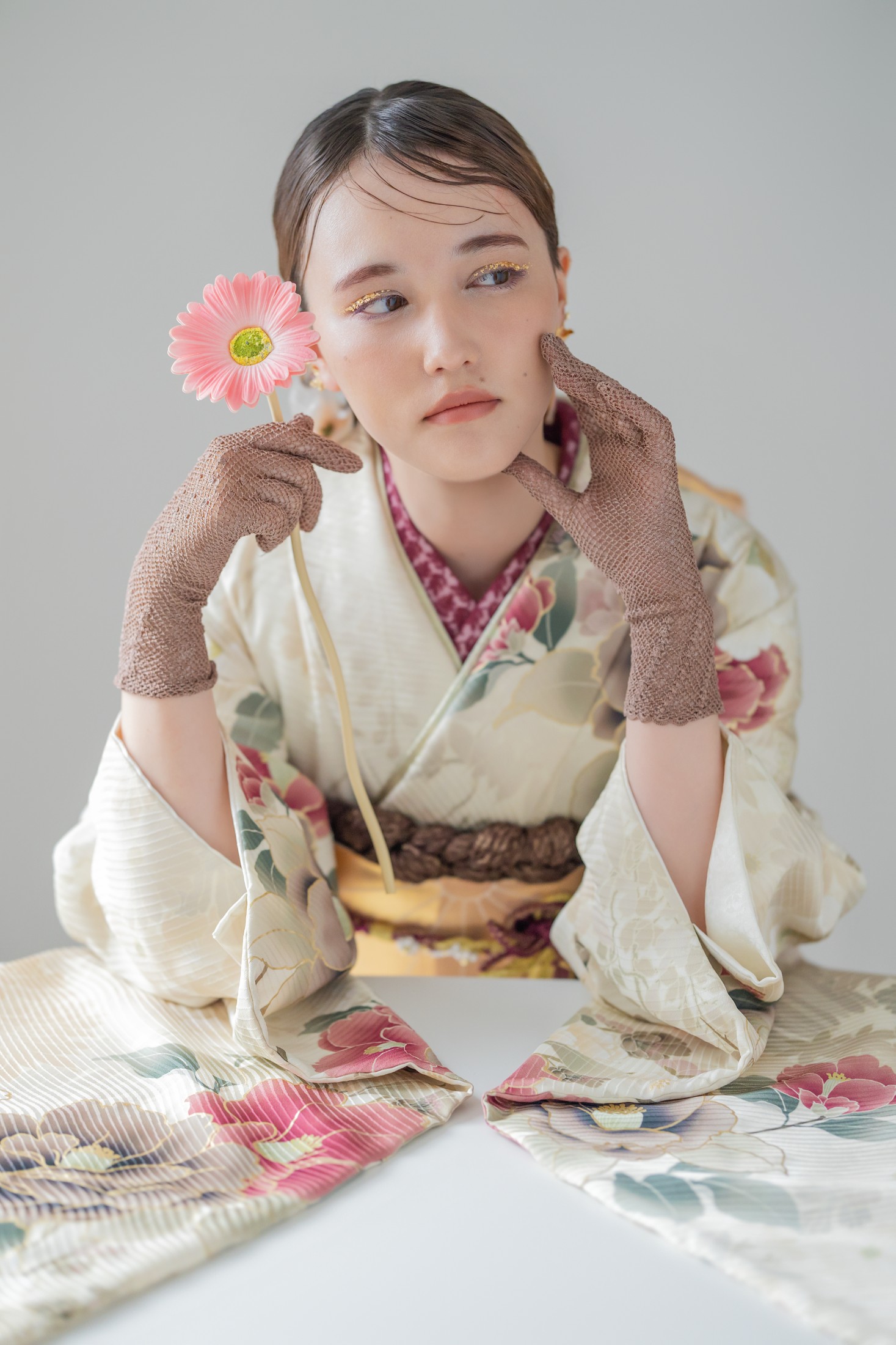 生成りの振袖でピンクの花を持って撮影した成人式写真