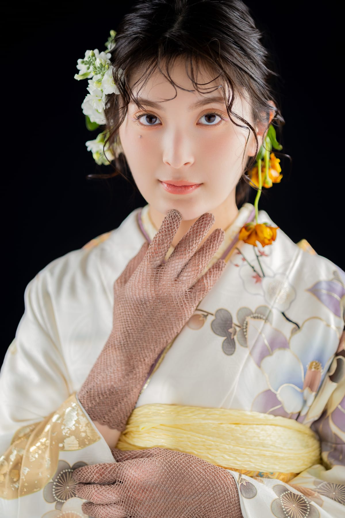 白地に花の振袖。黄色い帯で頬に手を添えた寄りです。成人式の前撮り写真