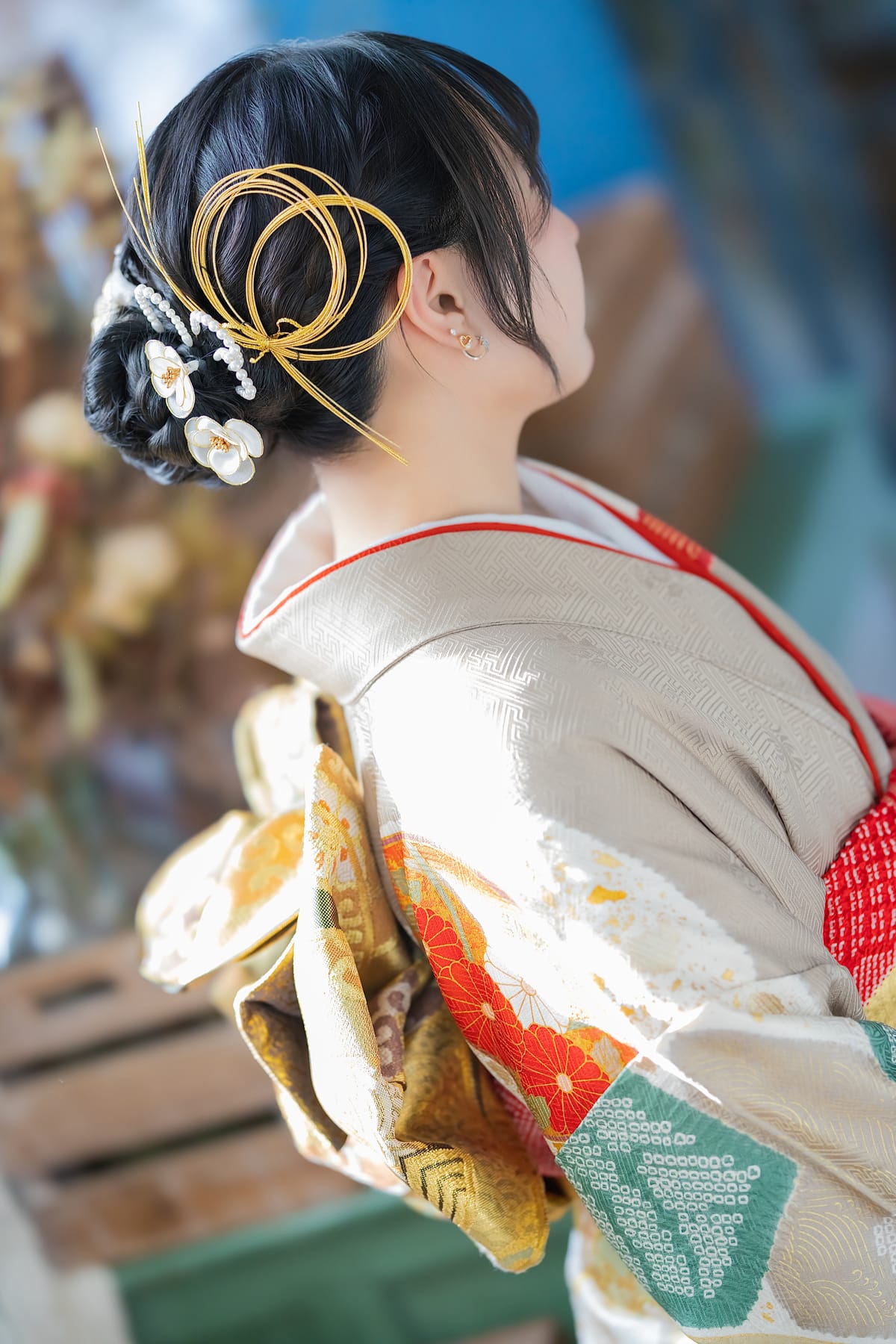 金の輪と白い花の髪飾りをつけた後ろ姿の寄り