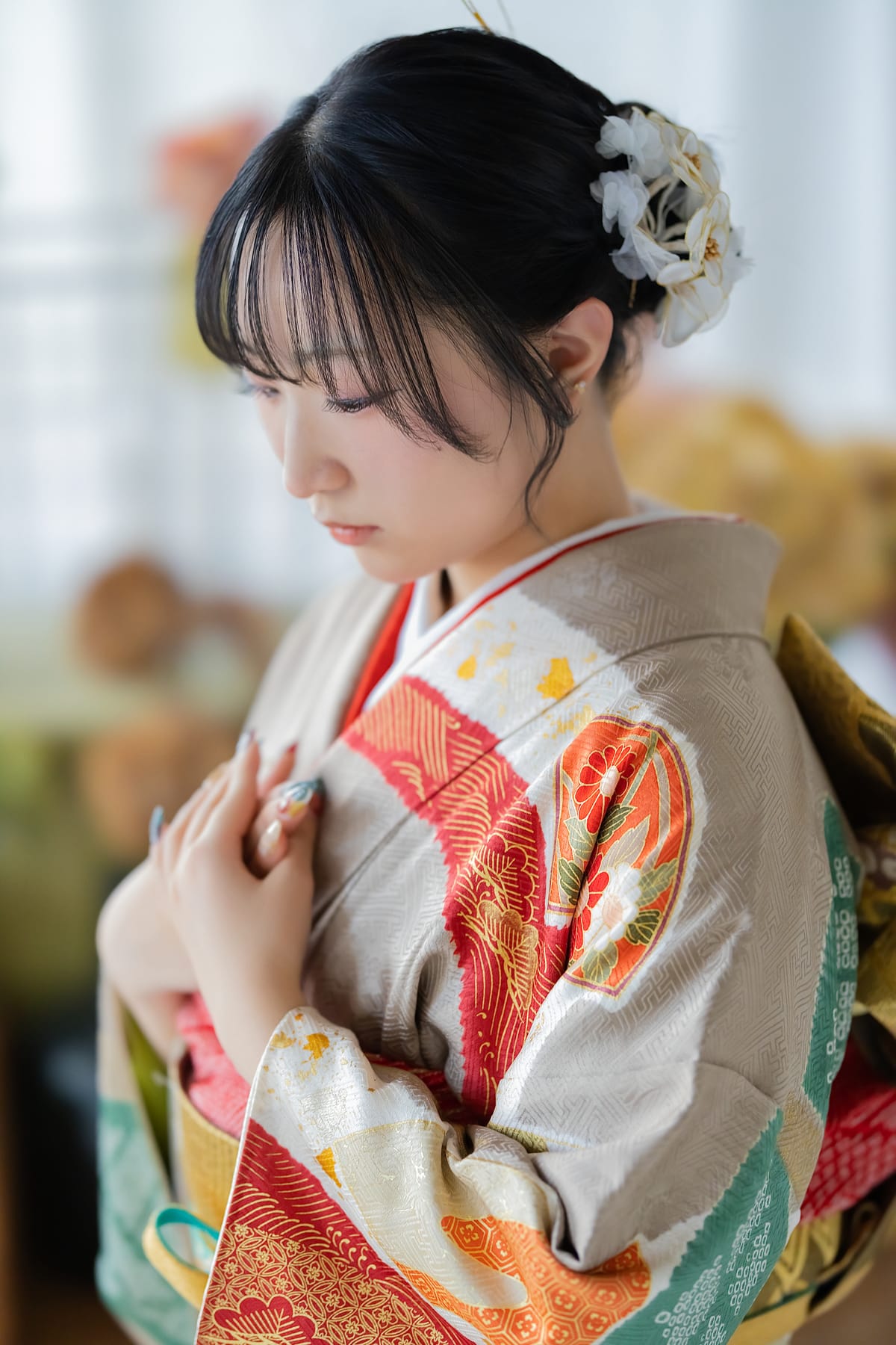 生成りに朱の花の振袖。目を伏せた寄りです。成人式の前撮り写真