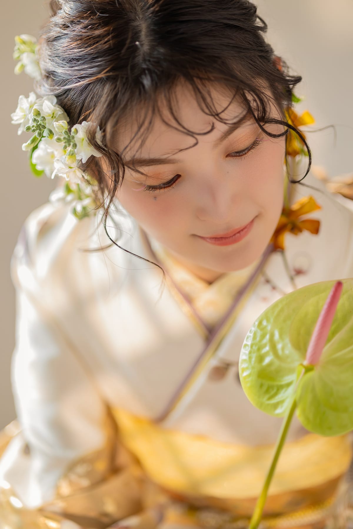 白と金の淡い花柄の振袖。金の帯と重ね衿が見える寄り