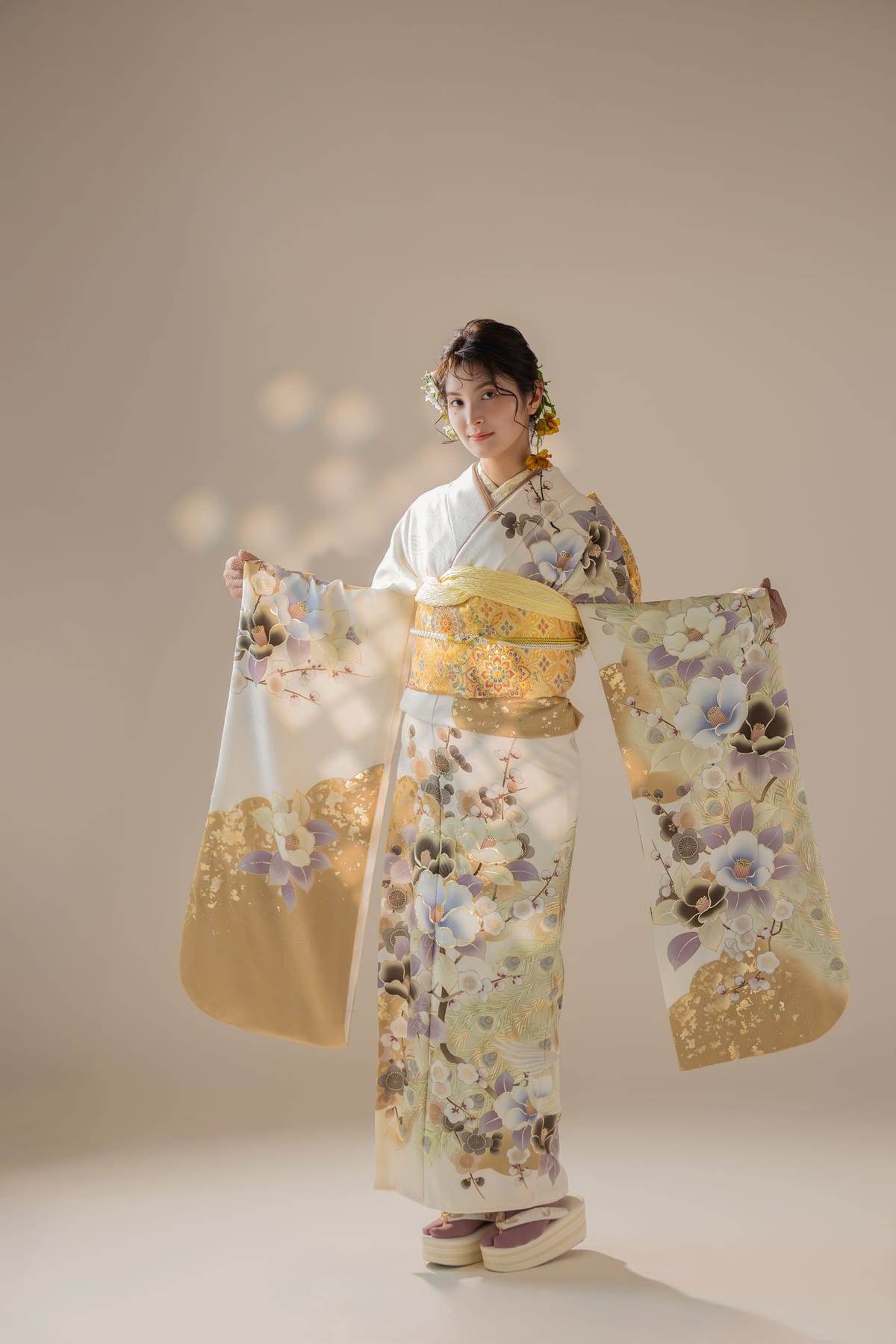 白と金の淡い花柄の振袖。袖を広げた全身