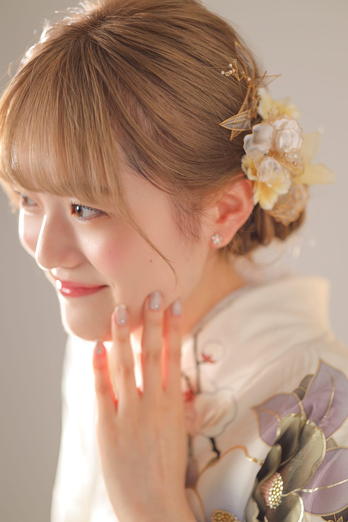 生成りの振袖。金と白の花の髪飾りをつけた寄り