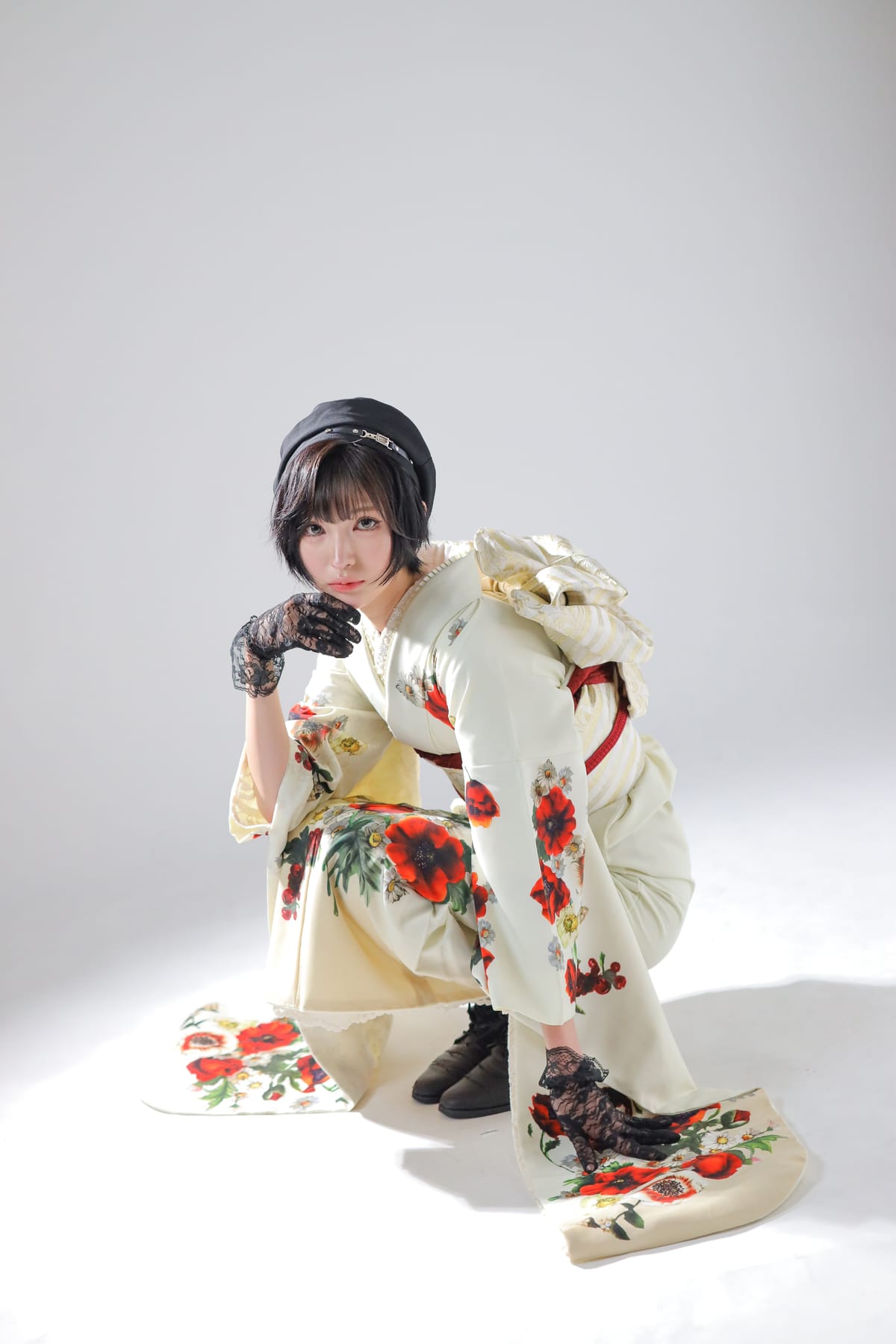 生成りに赤い花の振袖。片膝をついた姿