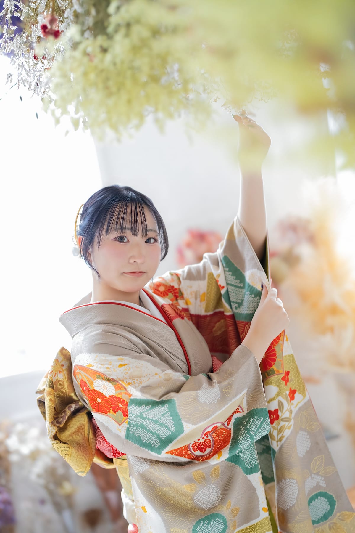生成りに黒い花の振袖。袖を広げて生地を見せた姿
