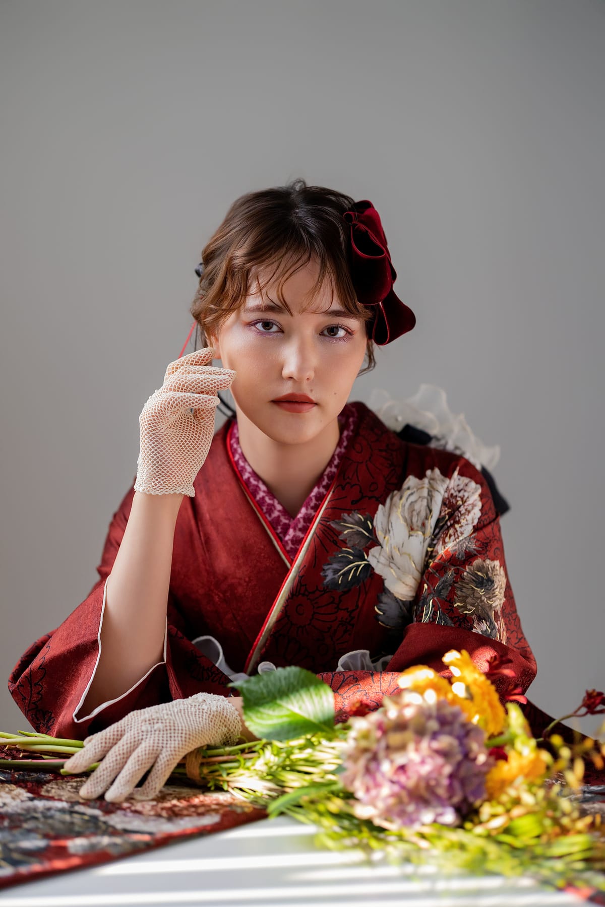 臙脂の振袖。頬に手を添えて座る上半身