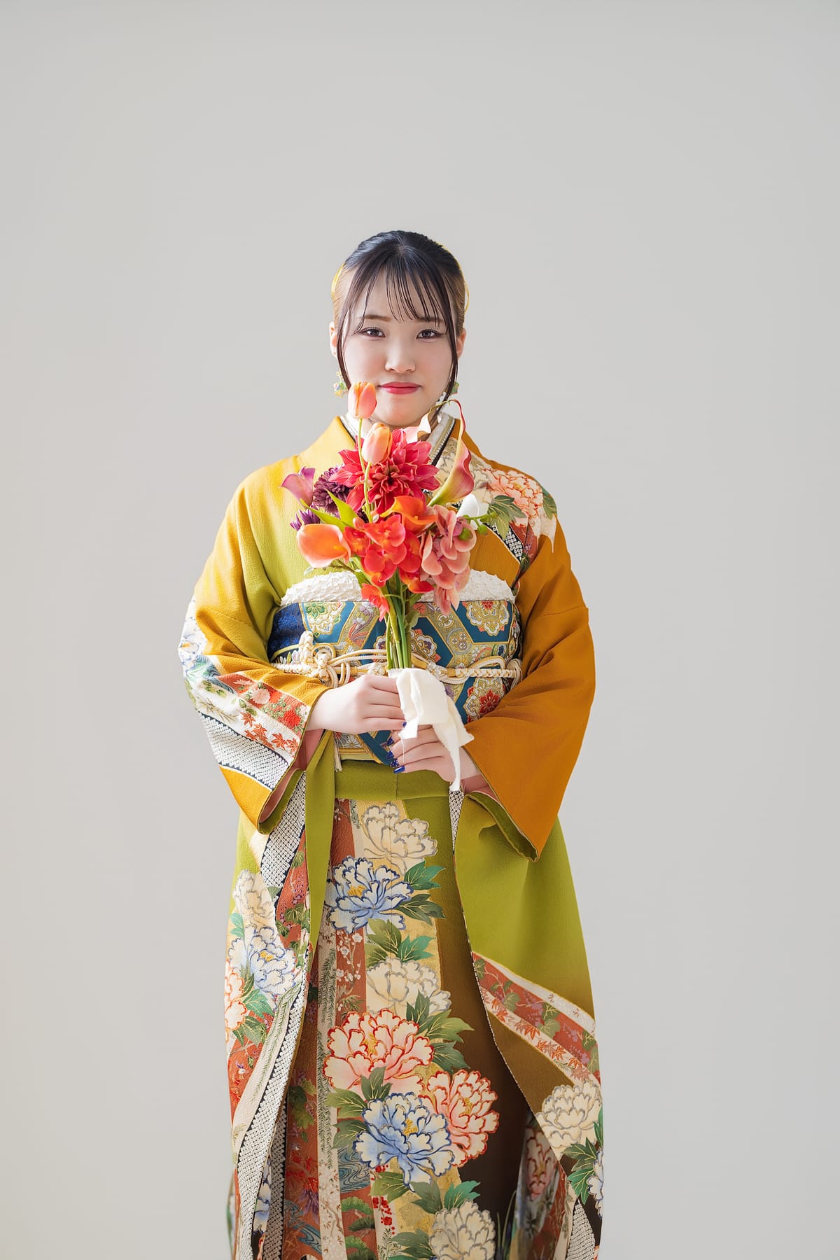 山吹と若草の振袖。花を持って立つ全身