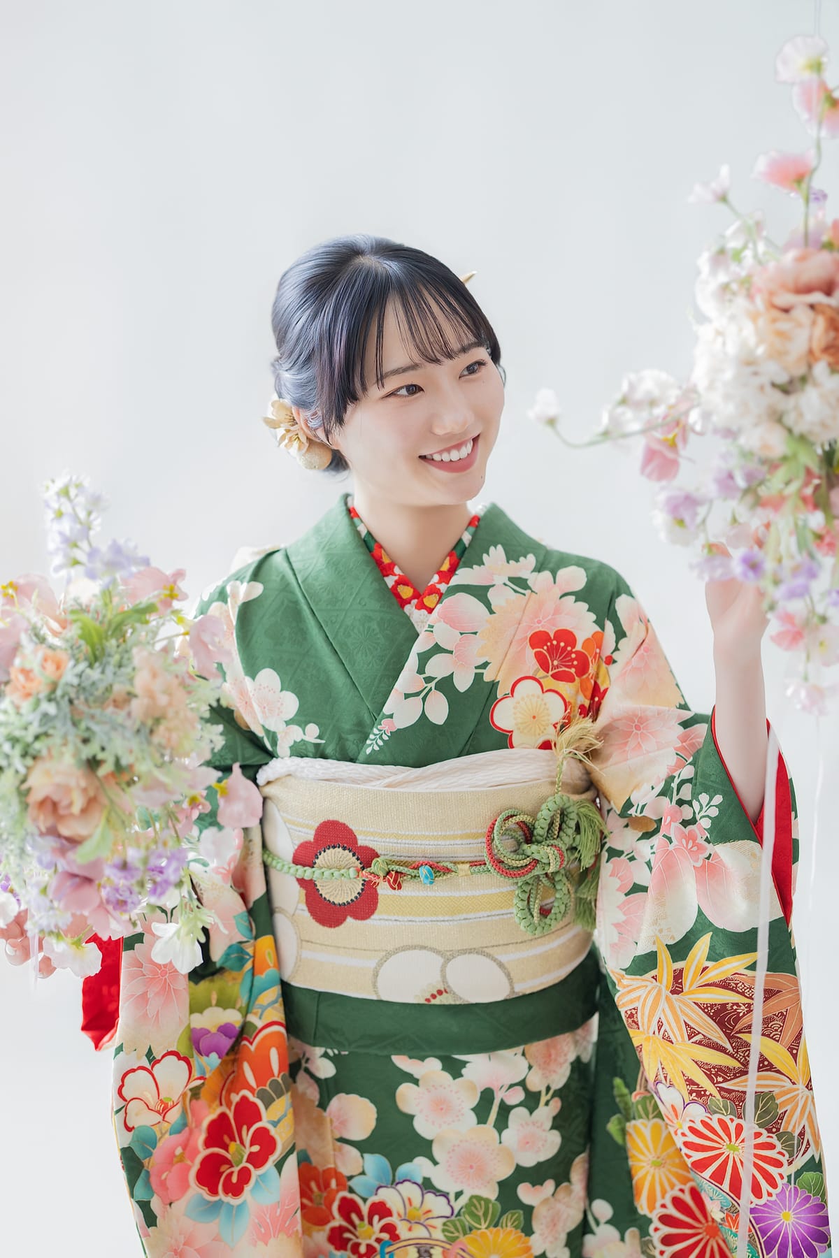 緑地に花の振袖。桜の枝に手を伸ばす上半身