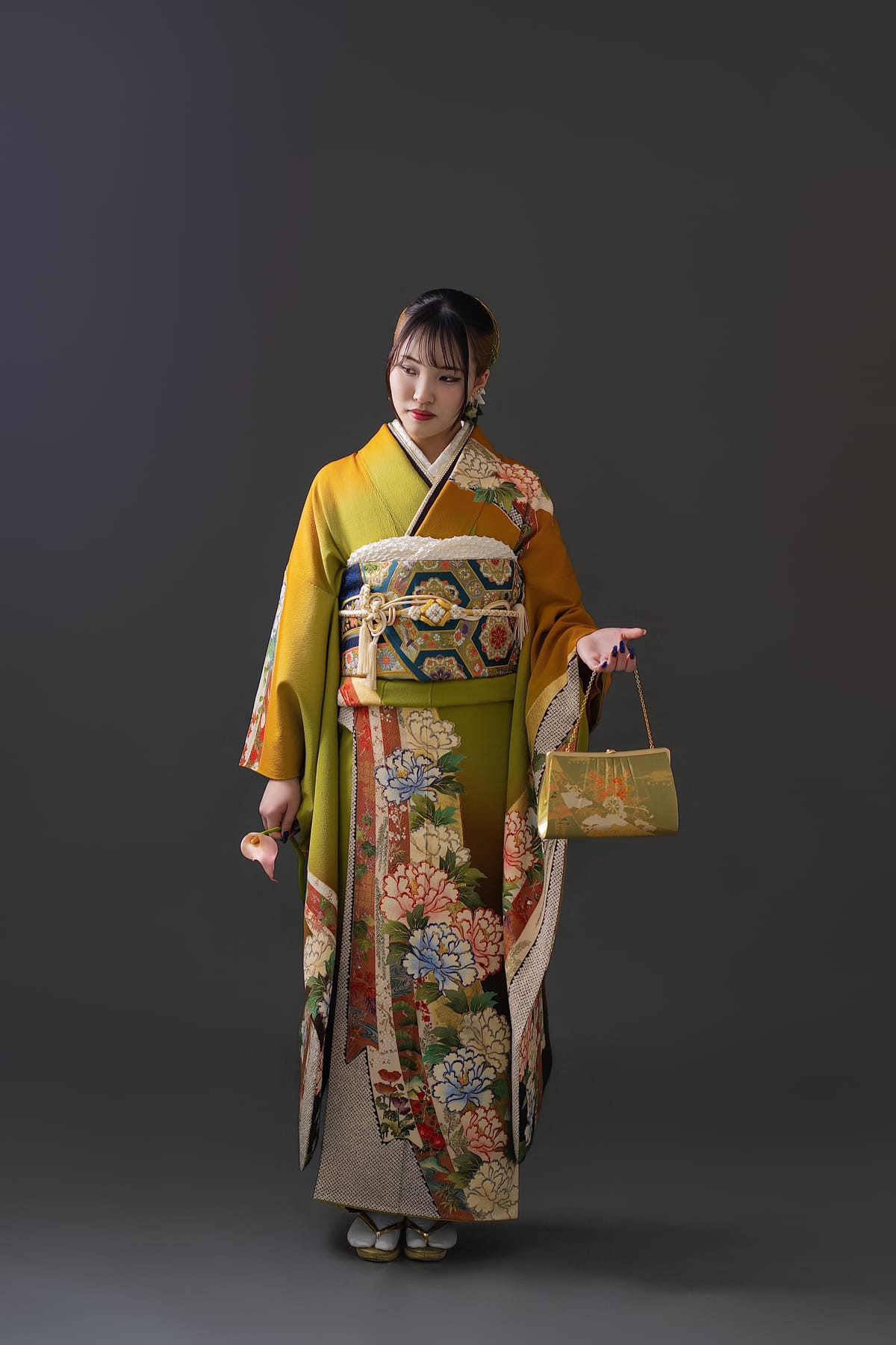 山吹の振袖。バッグを提げて立つ全身