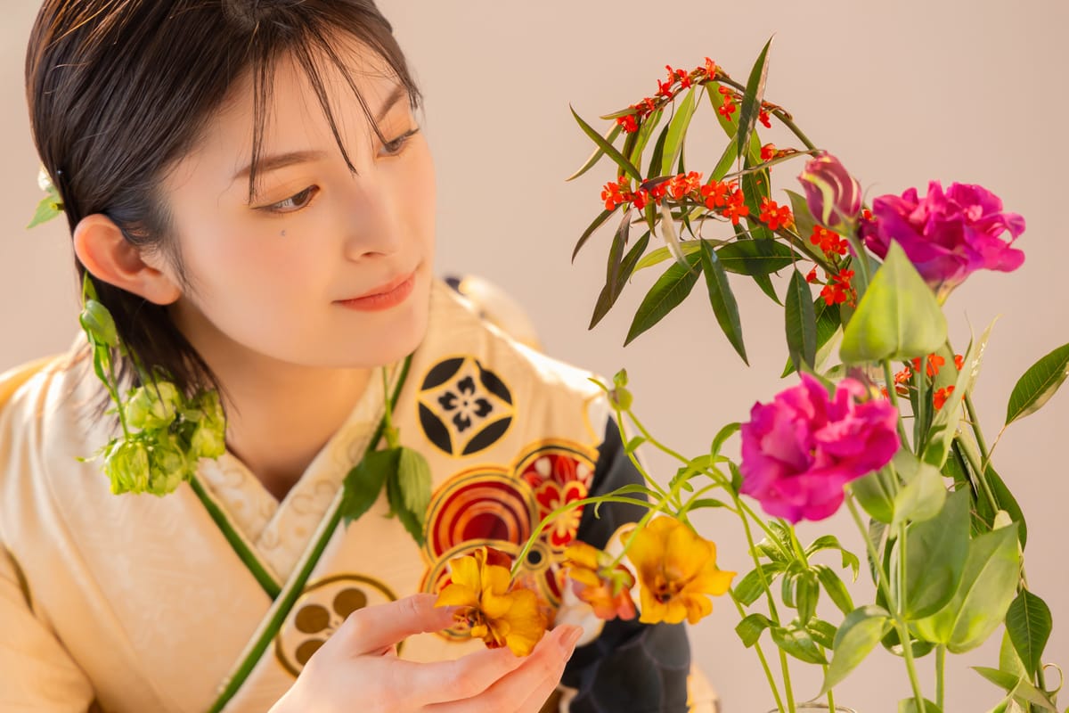 黄色の振袖。花を手にして目を向けた横位置の寄り