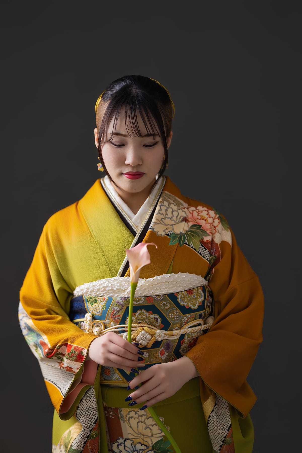 山吹の振袖。花を胸の前に持ち、目線を落とした上半身