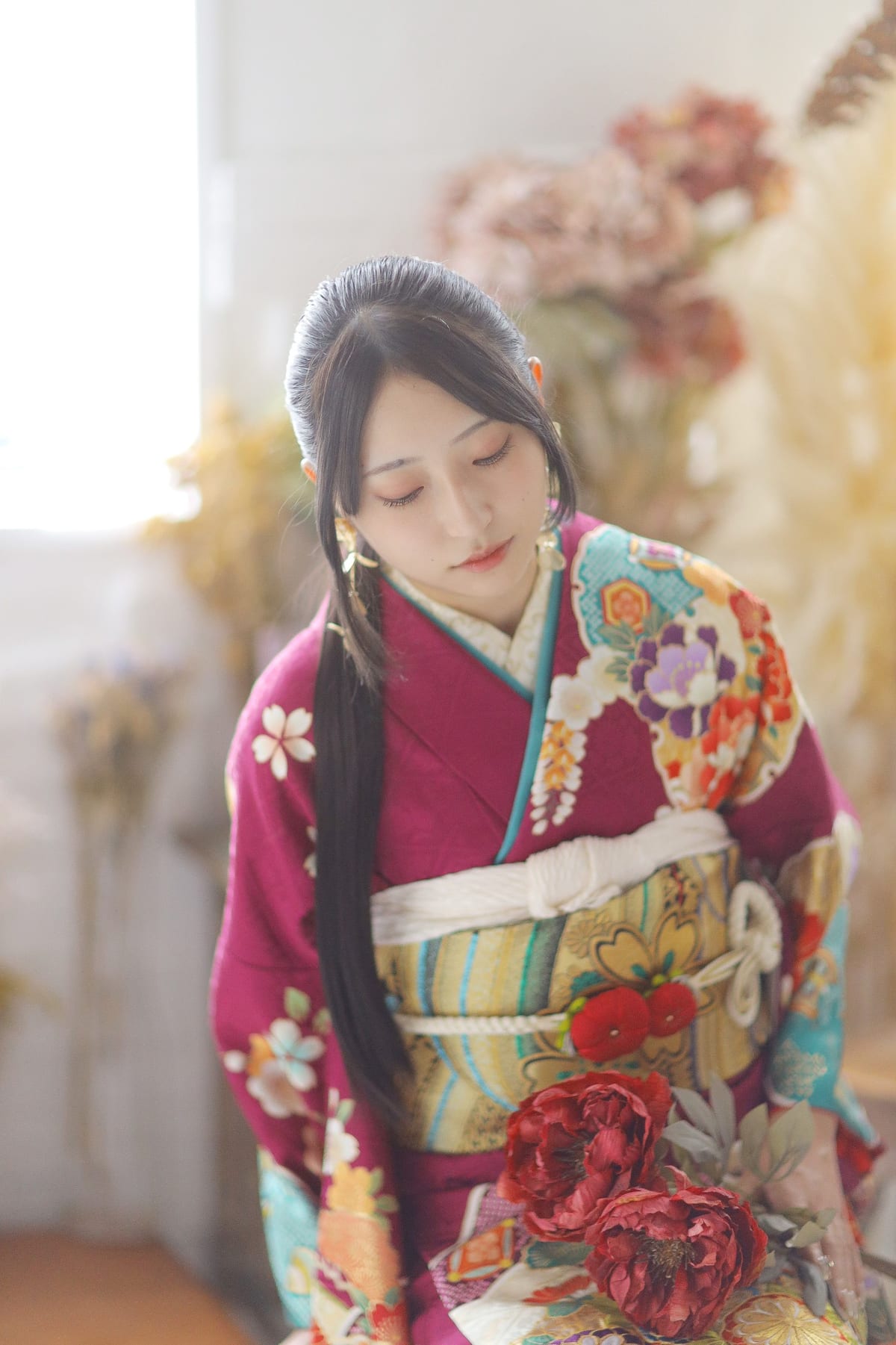 濃いピンクの振袖に水色の差し色と白いファーを合わせた成人式の前撮り写真